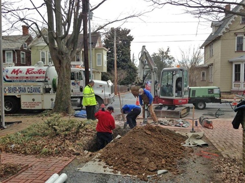 Sewer line replacement requiring careful excavation around utility lines