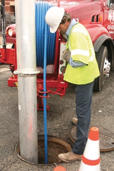 Vac-Con Combination truck using high pressure water jet hose to clean storm drain